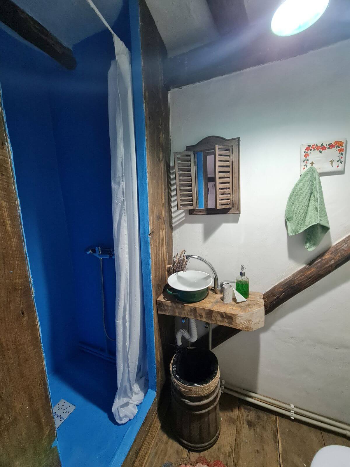Cabina de duș este o invenție a lui Dînuț Hotea care are o rețetă proprie de tencuială cu rol izolant. Astfel a reușit să facă o cabină perfect hidroizolată fără a folosi faianță. Și au ales nuanța de albastru care se regăsește și la nivelul tâmplăriei căsuței.
