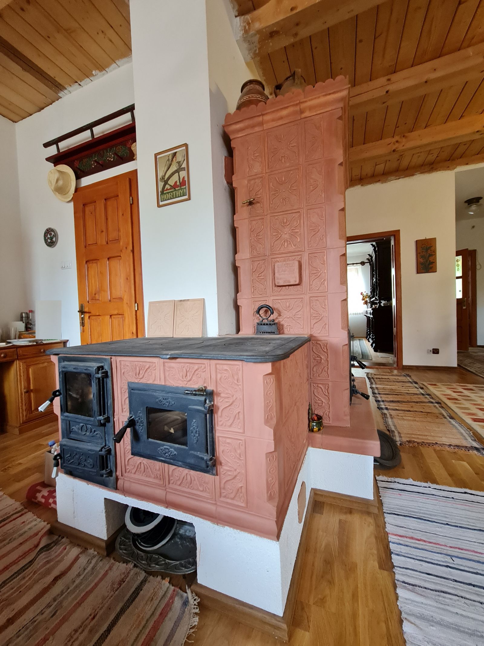 Către bucătărie soba are o extensie cu un loc de gătit care funcționează cu lemne.