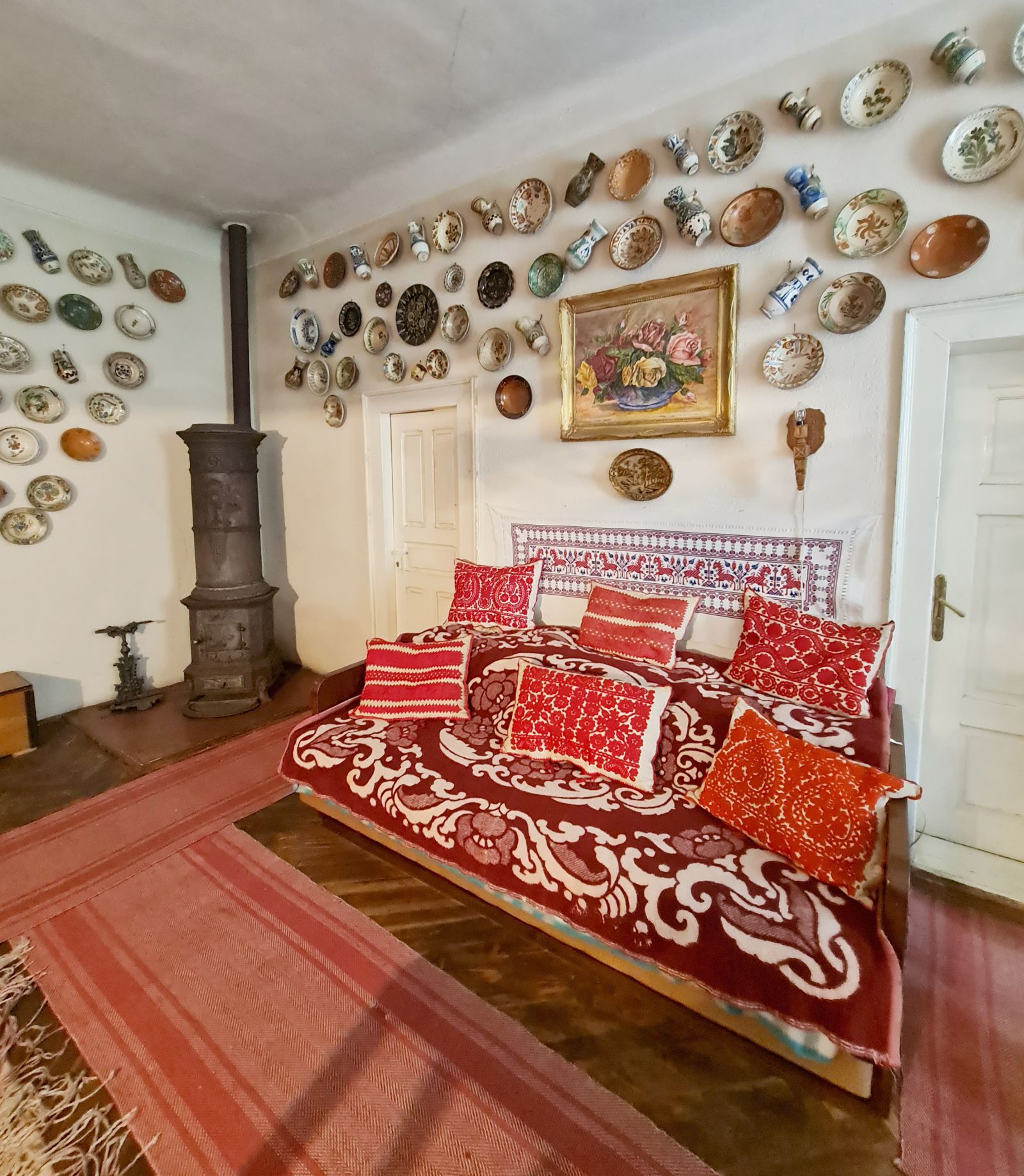 Într-o parte o sofa așa cum exista în multe case țărănești, decorată cu multe perne și nelipsita cuvertură.