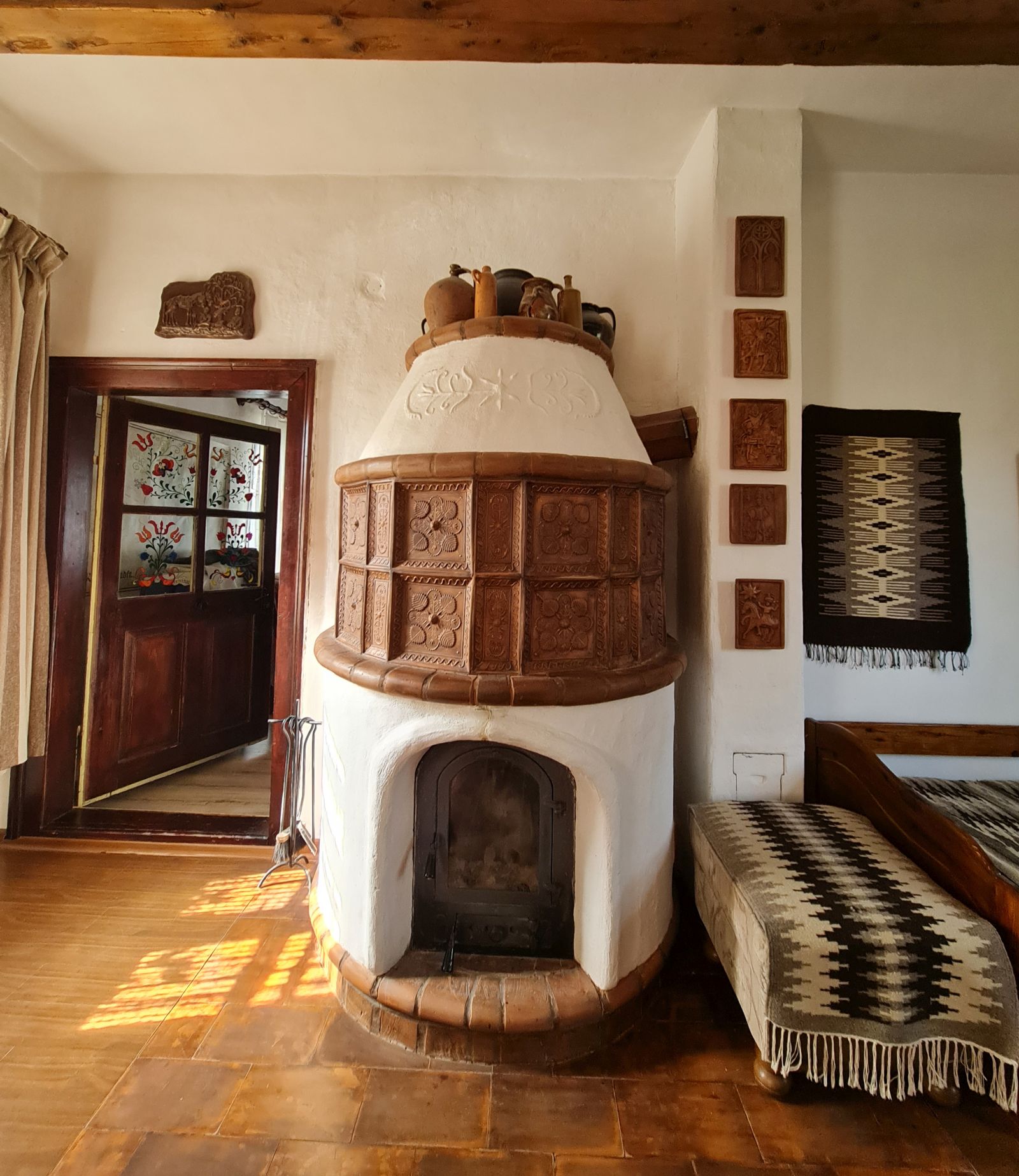 Mi-a plăcut mult cum și pe lângă soba frumoasă construită de Győző Hegyeli, pereții sunt decorați cu alte obiecte în ton. Inclusiv vasele de ceramică de deasupra sobei par a fi la locul lor.